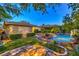 Backyard pool area showcasing a rock waterfall and lush landscaping at 10300 Wellside Hill Ave, Las Vegas, NV 89145