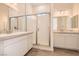Modern bathroom with dual sinks, white cabinets, a glass shower door, and tiled floor at 105 Barkset Way, Henderson, NV 89011