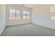 A bright bedroom with plush carpeting and large windows offering plenty of natural light at 107 Barkset Way, Henderson, NV 89011