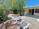 Backyard patio with seating area, complemented by mature trees and plants, perfect for outdoor enjoyment at 13 Desert Dawn Ln, Henderson, NV 89074