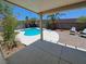 Backyard patio with pool view, featuring a covered area and chairs for outdoor relaxation at 13 Desert Dawn Ln, Henderson, NV 89074