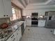 Bright kitchen with white cabinets, granite countertops, stainless steel appliances, and tile flooring at 13 Desert Dawn Ln, Henderson, NV 89074
