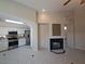 Living room showing the fireplace, tile floors, and open floor plan leading to the kitchen at 13 Desert Dawn Ln, Henderson, NV 89074