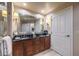 Well-lit bathroom featuring a double vanity with wood cabinetry and a large mirror at 135 E Harmon Ave # 809, Las Vegas, NV 89109