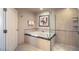 Bathroom with a bathtub and a glass-enclosed shower, white tiling and door to the side at 135 E Harmon Ave # 809, Las Vegas, NV 89109