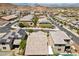 Aerial view of a neighborhood featuring modern homes, solar panels, and desert landscape at 145 Langley Hill Ave, Henderson, NV 89002