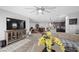 Bright living room features a large TV, decorative cabinet, tiled floors, and a modern ceiling fan at 145 Langley Hill Ave, Henderson, NV 89002