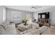 Comfortable living room with sectional sofa, television, plantation shutters, and neutral decor at 145 Langley Hill Ave, Henderson, NV 89002
