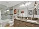 Modern bathroom with double sinks, marble countertop, and a tiled shower-tub combo at 15 Imposing Knoll Ave, Henderson, NV 89002