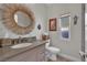 Modern bathroom featuring a sunburst mirror, elegant vanity, and plenty of natural light at 15 Imposing Knoll Ave, Henderson, NV 89002