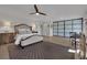 A luxurious bedroom with wood floors, ceiling fan, stylish rug, and wardrobe closet at 15 Imposing Knoll Ave, Henderson, NV 89002