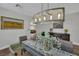 Dining room featuring decorative chandelier, glass-top table, and views to the living room at 15 Imposing Knoll Ave, Henderson, NV 89002