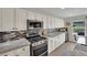 Kitchen with stainless steel appliances, gas range, granite counters, and ample storage in white cabinets at 15 Imposing Knoll Ave, Henderson, NV 89002