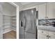 Modern kitchen featuring stainless steel LG refrigerator and walk-in pantry with shelving at 15 Imposing Knoll Ave, Henderson, NV 89002
