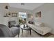 Comfortable living room with a white couch, soft chairs and natural light from the window at 15 Imposing Knoll Ave, Henderson, NV 89002