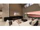 A modern living room with a fireplace, a TV, a large sofa, and a view of the water at 1516 Pleasant Bay Ct, Henderson, NV 89011