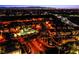 Night aerial view of a community with a pool, illuminated streets, and city skyline at 1557 Blue Sierra Ct, Henderson, NV 89074