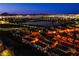 Dusk aerial view of homes with a lake and illuminated city lights at 1557 Blue Sierra Ct, Henderson, NV 89074