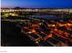 Night aerial perspective features illuminated houses next to a serene lake and city lights, blending nature with urban living at 1557 Blue Sierra Ct, Henderson, NV 89074
