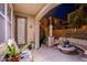 Cozy back patio with stone pillars, concrete seating, potted plants, and outdoor lighting at 1557 Blue Sierra Ct, Henderson, NV 89074