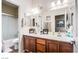 Well-lit bathroom featuring double sinks with wood cabinets and a large mirror, providing ample space and functionality at 1557 Blue Sierra Ct, Henderson, NV 89074