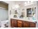 Bathroom featuring double sinks, a large mirror, and a shower with glass doors at 1557 Blue Sierra Ct, Henderson, NV 89074
