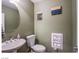 Cozy bathroom features a pedestal sink, toilet, and decorative wall art for a comfortable, stylish space at 1557 Blue Sierra Ct, Henderson, NV 89074