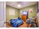A bedroom with olive green colored walls featuring wood floors and bright lighting at 1557 Blue Sierra Ct, Henderson, NV 89074