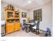 A charming dining area featuring a glass-top table with black chairs, complemented by a wood china cabinet at 1557 Blue Sierra Ct, Henderson, NV 89074