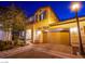 Inviting two-story home boasts a two-car garage, brick driveway, manicured landscaping, and cozy curb appeal at 1557 Blue Sierra Ct, Henderson, NV 89074