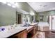 Well-lit main bathroom with double sinks, large mirror, soaking tub, and separate shower at 1557 Blue Sierra Ct, Henderson, NV 89074