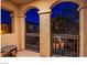 Cozy covered patio featuring arched columns and wrought iron railings, perfect for outdoor relaxation and enjoyment at 1557 Blue Sierra Ct, Henderson, NV 89074