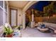 Inviting outdoor patio area with comfortable seating, potted plants, and an adjacent landscaped backyard at 1557 Blue Sierra Ct, Henderson, NV 89074