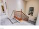 Carpeted staircase with wooden railing leading to the second floor, illuminated by natural light from an arched window at 1557 Blue Sierra Ct, Henderson, NV 89074