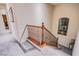 Carpeted staircase with wooden banister and decorative window offers a bright and inviting transition between floors at 1557 Blue Sierra Ct, Henderson, NV 89074