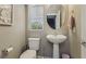 Well-lit powder room features pedestal sink, round mirror, and neutral wall color at 1922 Via Delle Arti, Henderson, NV 89044