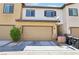 Exterior view of a townhome featuring a two-car garage, neat landscaping, and a cozy facade at 1922 Via Delle Arti, Henderson, NV 89044