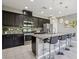Stylish kitchen featuring dark cabinetry, granite countertops, and a breakfast bar with seating at 1922 Via Delle Arti, Henderson, NV 89044