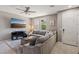 Cozy living room with a plush sectional sofa, modern entertainment center, and bright natural light at 1922 Via Delle Arti, Henderson, NV 89044