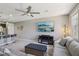 Open-concept living room with a stylish gray sofa, sleek entertainment unit, and adjacent kitchen area at 1922 Via Delle Arti, Henderson, NV 89044