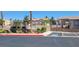 Pool area featuring a secured fence, surrounding vegetation, parking, and community pool at 2050 N Los Feliz St # 170, Las Vegas, NV 89156