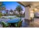 Serene covered patio with comfortable seating, a dining table, and views of the sparkling pool and tropical landscaping at 2285 Villefort Ct, Las Vegas, NV 89117