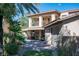 A home's exterior with a covered patio, lush trees, and a two-car garage at 2285 Villefort Ct, Las Vegas, NV 89117