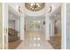 An elegant foyer with a chandelier, marble floors, and staircase at 2285 Villefort Ct, Las Vegas, NV 89117