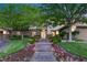 Charming home exterior with stone accents, manicured lawn, colorful flowers, and a welcoming entrance at 2285 Villefort Ct, Las Vegas, NV 89117