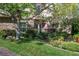 Charming home featuring a stone facade, a well-kept lawn, and lush landscaping with mature trees at 2285 Villefort Ct, Las Vegas, NV 89117