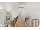 Second floor hallway with decorative railing, carpet floor, and natural light from a large window at 2285 Villefort Ct, Las Vegas, NV 89117