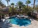 An elevated view of a private pool and spa surrounded by lush landscaping and stone accents at 2285 Villefort Ct, Las Vegas, NV 89117