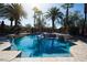 A luxurious backyard swimming pool features palm trees, a waterfall and spa for relaxation and recreation at 2285 Villefort Ct, Las Vegas, NV 89117