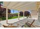 Relaxing backyard patio with pergola, outdoor seating, manicured lawn, and beautiful landscaping at 2297 Aria Dr, Henderson, NV 89052